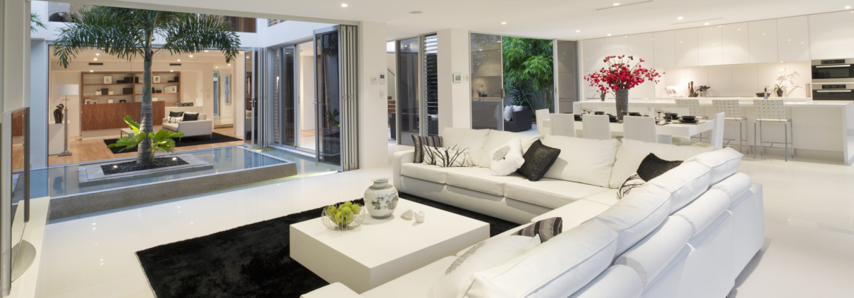 Living room with spacious windows and open floor plan that goes to kitchen.