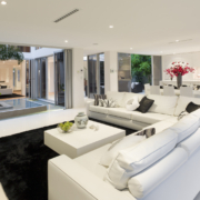 Living room with spacious windows and open floor plan that goes to kitchen.